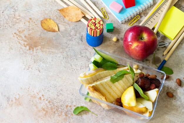 Foto de volta à escola com material escolar, caixa de almoço e maçã.