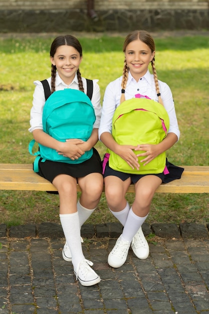De volta à escola, duas crianças adolescentes alegres depois da amizade ao ar livre da escola de meninas da escola