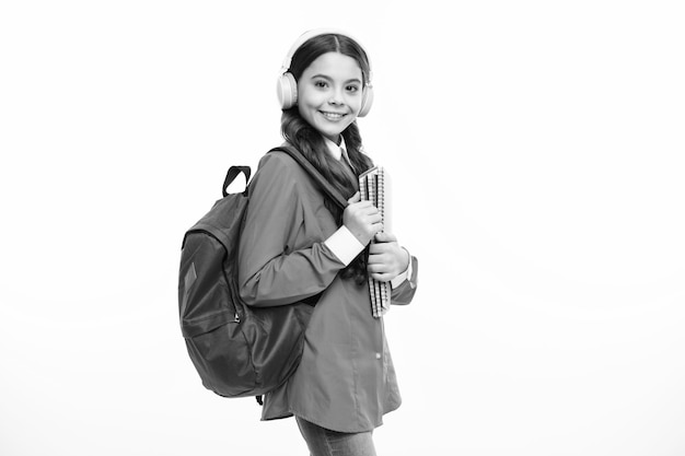 De volta à escola Estudante em fones de ouvido com mochila escolar em fundo de estúdio isolado Conceito de escola e educação Menina adolescente em uniforme escolar