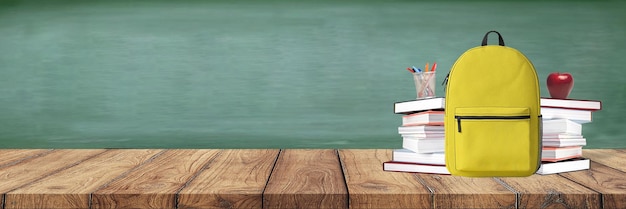 Foto de volta à escola. mochila com livros e material escolar no fundo do quadro-negro