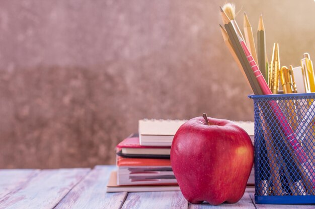 De volta à escola notebookalarmpencil e maçã vermelha com luz solar da manhã