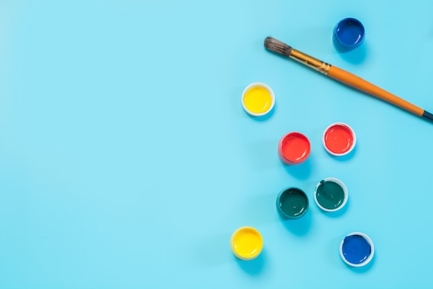 De volta à escola. pinturas coloridas e escova no azul punchy. copie o espaço.