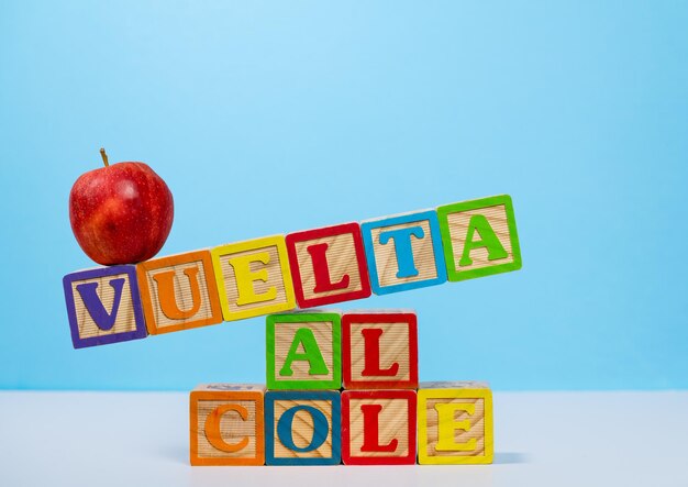 De volta à escola soletrado em espanhol com blocos de madeira com maçã