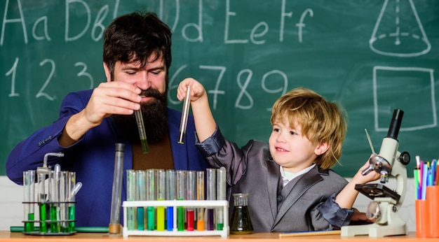 De volta ao acampamento de ciências da escola experiência de béquer de química pai e filho na escola professor homem com garotinho laboratório de educação escolar pesquisa e desenvolvimento inovação na instalação