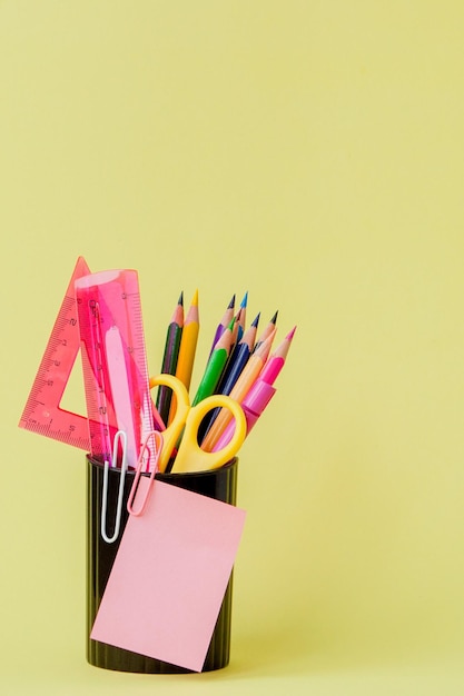 De volta ao conceito de escola com espaço para texto Copie o espaço Material de escritório escolarMesa criativa com artigos de papelaria coloridos Clipe de papel coloridoMaterial escolar em fundo amareloMesa de escritório