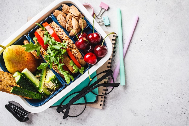 De volta ao conceito de escola com lancheira com sanduãche, frutas, lanches, notebook