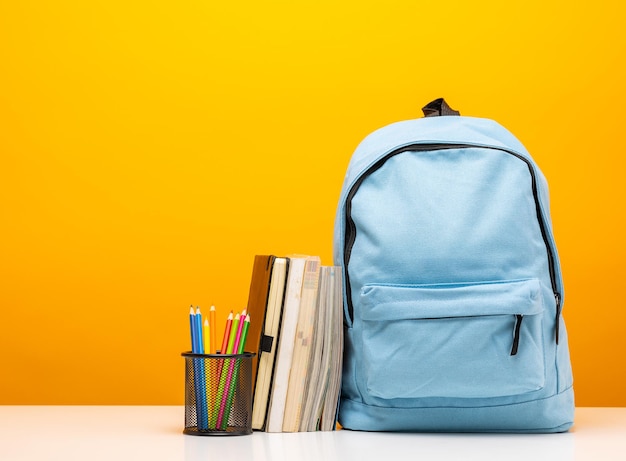 De volta ao fundo da escola Artigos de papelaria na mochila escolar Educação em design de banner em fundo amarelo