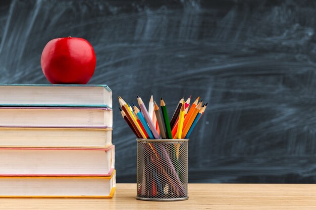 De volta ao fundo da escola com livros e maçã sobre o quadro-negro