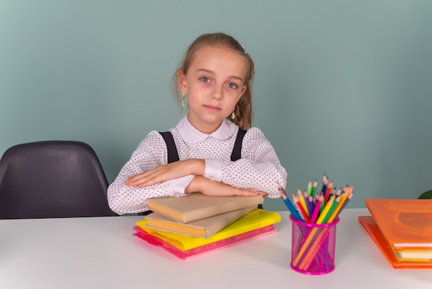 De volta às aulas Pensando criança, menino, escrevendo, desenhando no caderno, sentado na mesa e fazendo a lição de casa