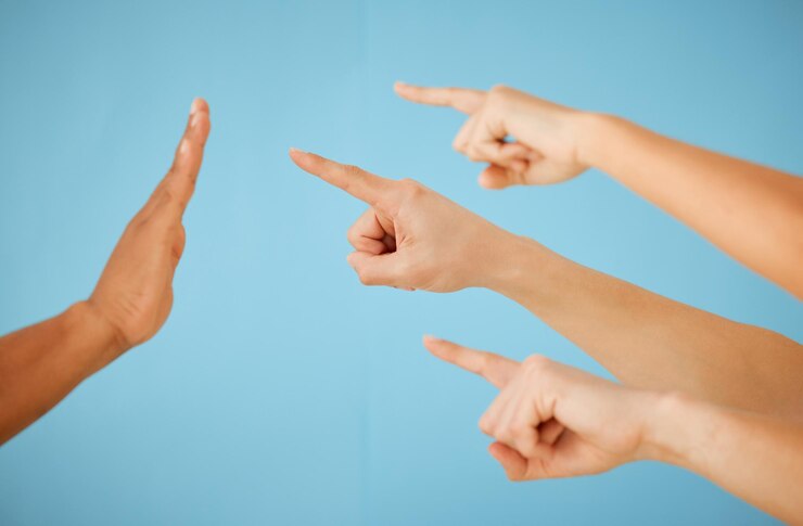 Foto esto debe ponerse en espera toma de un grupo irreconocible de personas que apuntan hacia la mano tendida en un gesto de parada contra un fondo azul