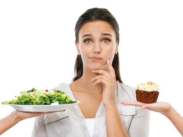 ¿Debería o no una foto de estudio de una mujer joven que elige entre una dieta saludable y una dieta no saludable?