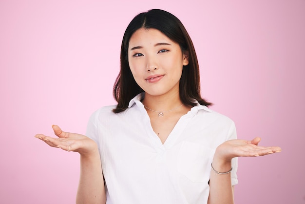 Decisão de dúvida e retrato de mulher asiática em fundo rosa para incerteza insegura e pergunta Pensamento confuso e rosto de pessoa com gesto de mão para escolha de opção e emoji em estúdio