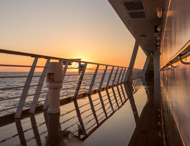 Deck auf einem kleinen Kreuzfahrtschiff, das bei Sonnenaufgang über den Ozean segelt