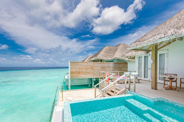 Deck de terraço privado de luxo de bangalô sobre a água com vista para a piscina infinita no oceano turquesa