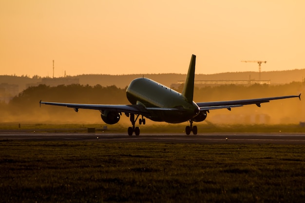 Decole de um avião de passageiros ao pôr do sol do dia