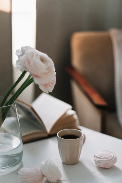 decoração aconchegante com um livro de flores e xícara de café à luz da manhã