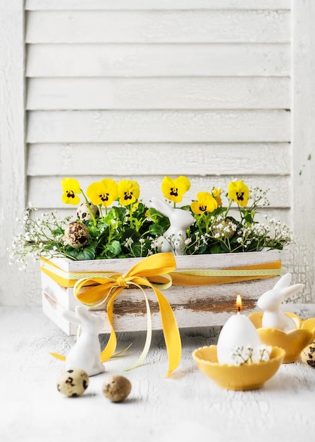 Decoração artesanal feita com flores amarelas de viola na velha caixa de madeira vintage para a Páscoa