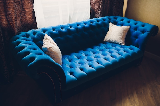 Foto decoração bastante simples da sala de estar com sofá azul e luz.