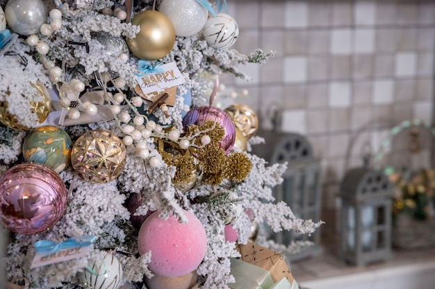 Decoração da árvore de natal. Bolas de Natal em ouro, prata, enfeites de Natal rosa e branco, bolas de glitter e uma estrela de floco de neve. Decoração para casa festiva. Linda árvore de Natal decorada