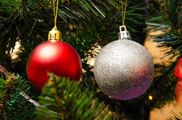 Decoração da árvore de natal. Bolas, estrelas guirlanda em uma árvore. Arcos vermelhos em uma árvore de ano novo. A árvore festiva é decorada com brinquedos brilhantes. Clima de ano novo. feliz Natal