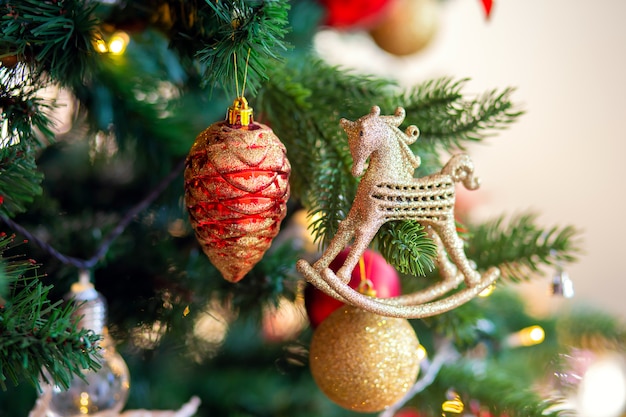 Decoração da árvore de natal. Colisão e cavalo de vidro dourado em um close-up da filial