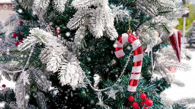 Foto decoração da árvore de natal com neve branca varas de cana vermelhas e brancas feliz natal e feliz feriado quadro de cartão de saudação bandeira ano novo tema de feriado de inverno