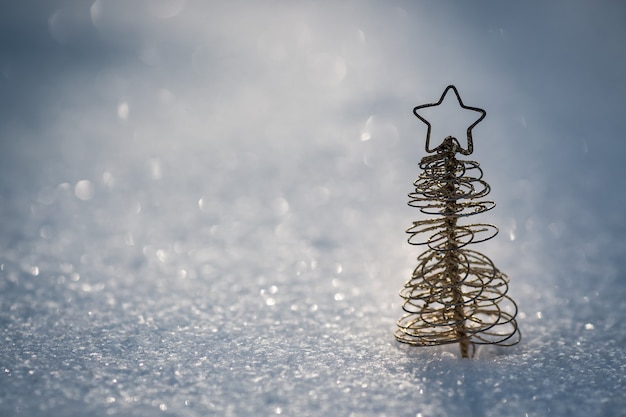 Foto decoração da árvore de natal na neve real ao ar livre. conceito de férias de inverno. profundidade superficial de campo