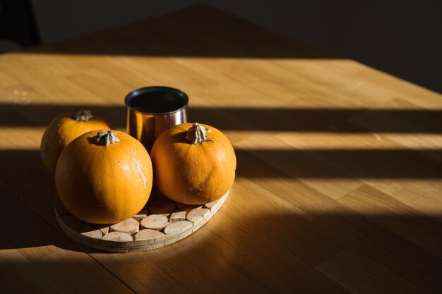 Foto decoração de abóbora na mesa de madeira em casa à luz do sol.