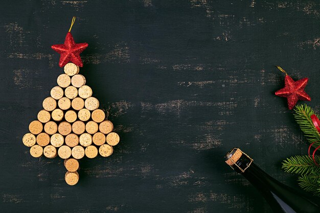 Foto decoração de ano novo com árvore de natal feita de rolhas de vinho e garrafa de champanhe fundo de natal vista superior