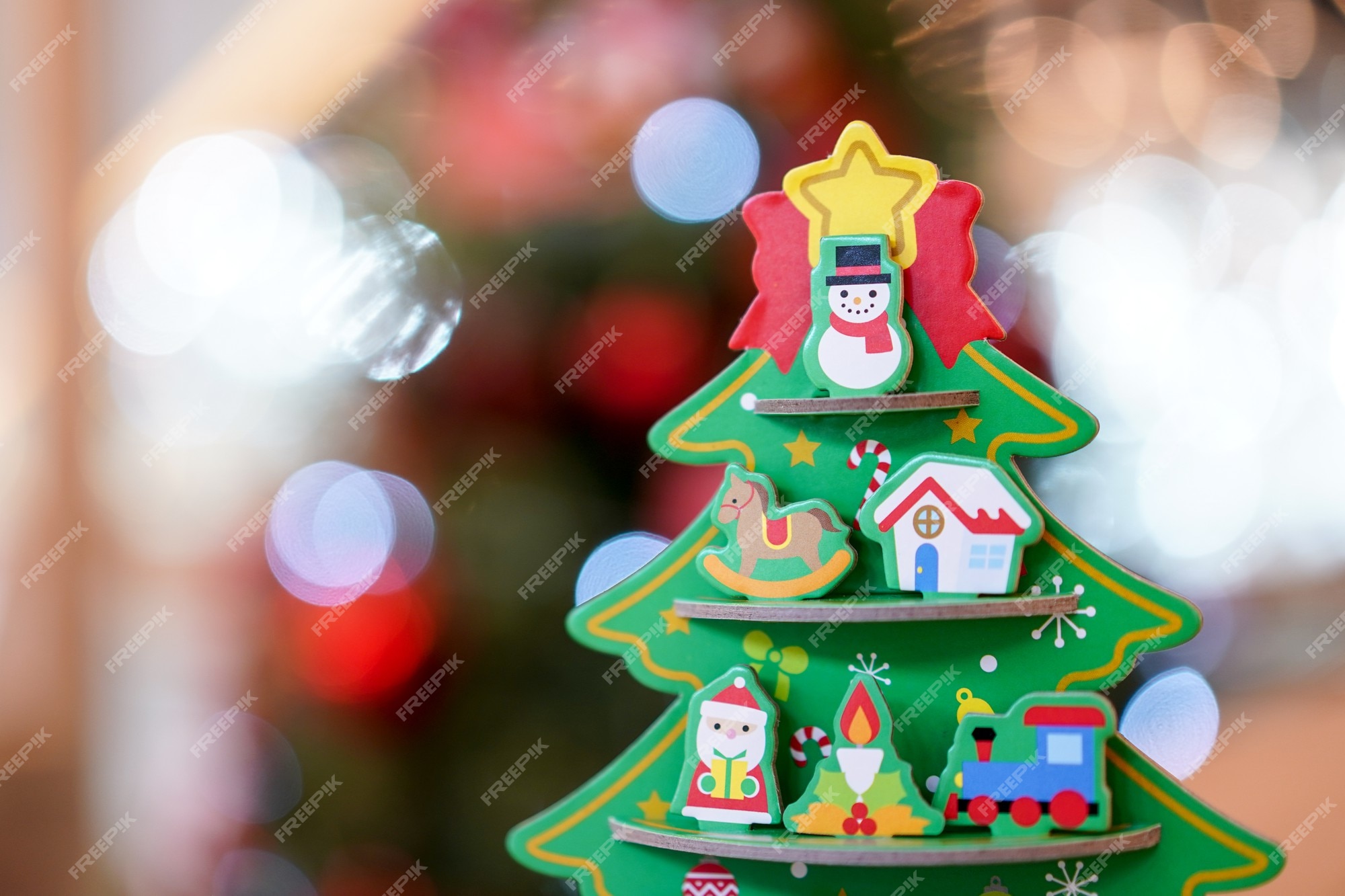 Decoração de artesanato de papel de árvore de natal na mesa de madeira com  borrão de árvore de natal grande atrás.