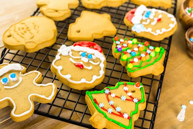 Decoração de biscoitos de gengibre com cobertura real e doces coloridos.