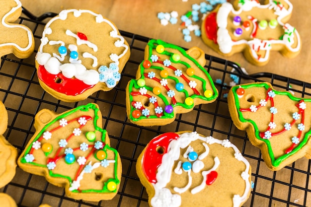 Decoração de biscoitos de gengibre com cobertura real e doces coloridos.