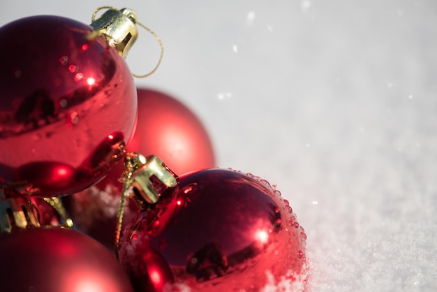 decoração de bolas vermelhas de natal em fundo de neve fresca em lindo dia ensolarado de inverno