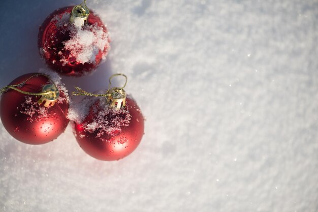 decoração de bolas vermelhas de natal em fundo de neve fresca em lindo dia ensolarado de inverno