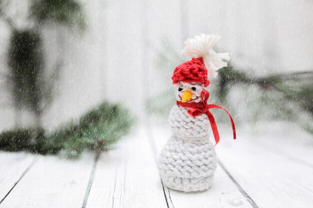 Decoração de boneco de neve de Natal com neve em fundo branco de madeira