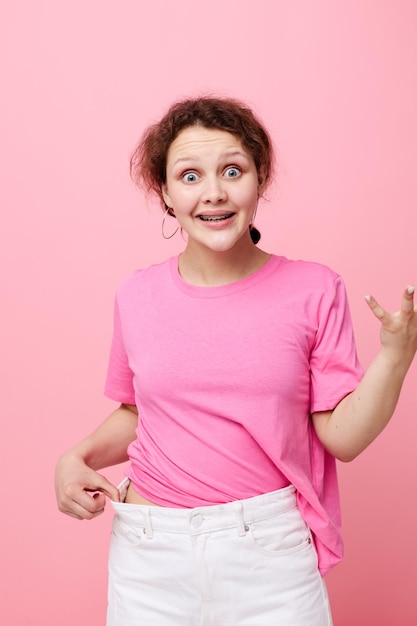 Decoração de camiseta rosa de moda jovem atraente posando estilo de vida inalterado