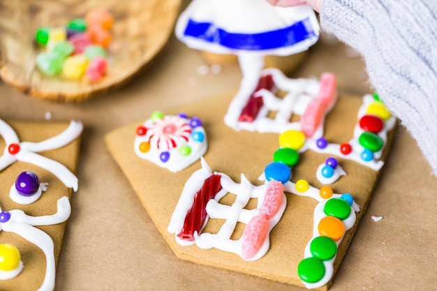 Decoração de casa de pão de gengibre com cobertura real e doces coloridos.