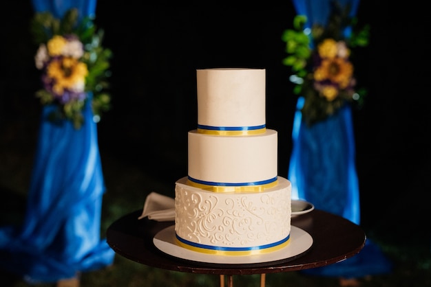 Decoração de casamento com bolo em um banco de madeira contra um fundo de cachoeira