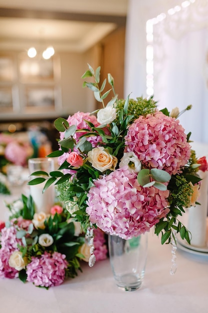 Decoração de casamento mesa festiva decorada com composição de flores cor-de-rosa roxas violetas e hortaliças no salão de banquetes