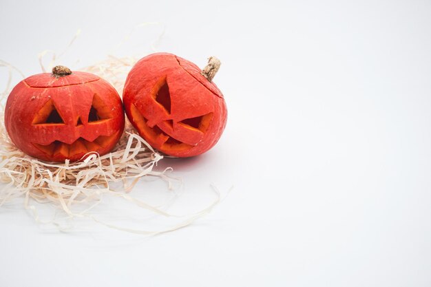 Decoração de dia das bruxas. Abóbora de Halloween. Abóbora esculpida. Duas abóboras em um fundo branco.