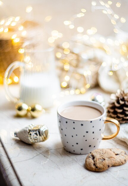 Decoração de férias de inverno aconchegante, luzes de natal e xícara de café com detalhes de decoração em casa real