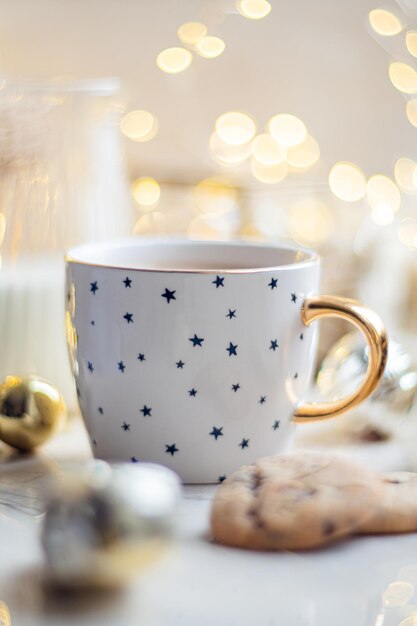 Decoração de férias de inverno aconchegante, luzes de Natal e xícara de café com detalhes de decoração em casa real