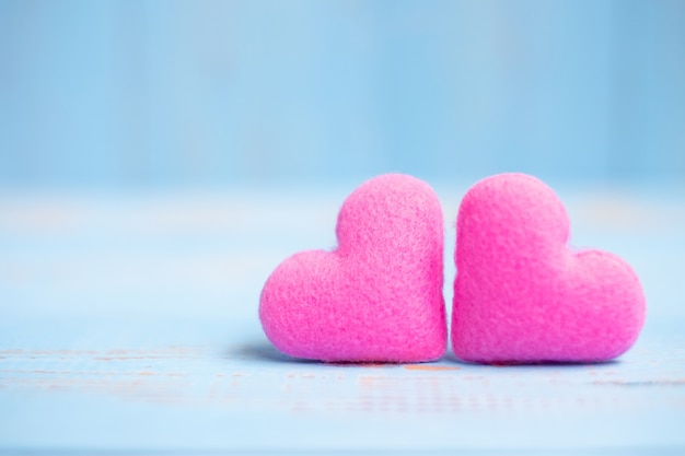 Decoração de forma de coração casal rosa no fundo da mesa de madeira azul