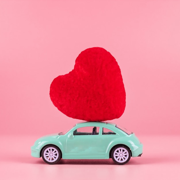 Decoração de forma de coração vermelho no brinquedo mini carro com espaço de cópia de texto em rosa. Amor, casamento, romântico e feliz dia dos namorados dia conceito