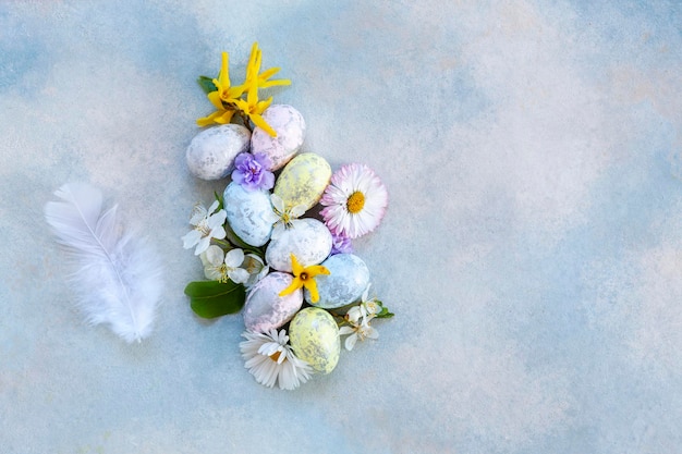 Decoração de fundo de Páscoa Ovos de Páscoa penas e flores de primavera Vista superior de perto da configuração plana