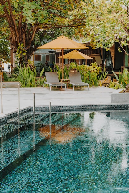 Foto decoração de guarda-sol e cama de piscina ao redor da piscina em hotel resort