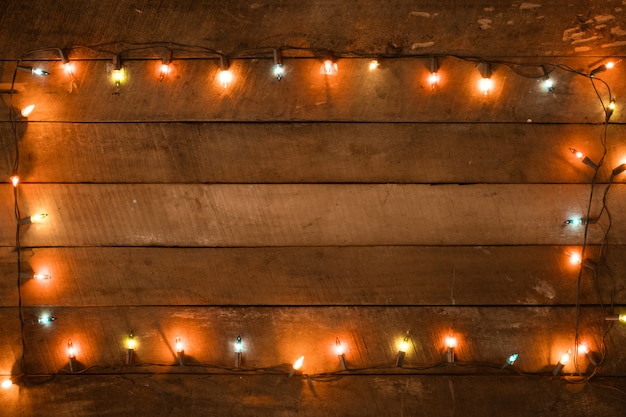 Decoração de lâmpada de luzes de Natal na prancha de madeira velha