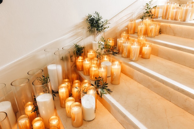 Decoração de layout de mesa de casamento romântico com grandes buquês de flores exuberantes, incluindo rosas brancas, ranúnculos, botões de ouro persas, orquídeas brancas e velas. foto de alta qualidade