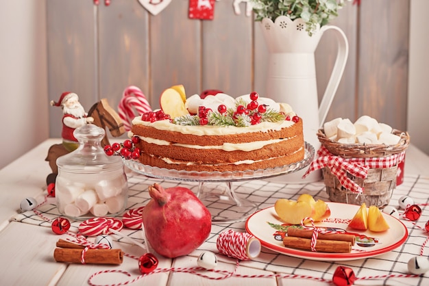 Decoração de mesa de Natal, bolo de frutas festivo com doces em cima da mesa