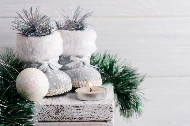 Decoração de Natal branca com botas de brinquedo em mesa rústica